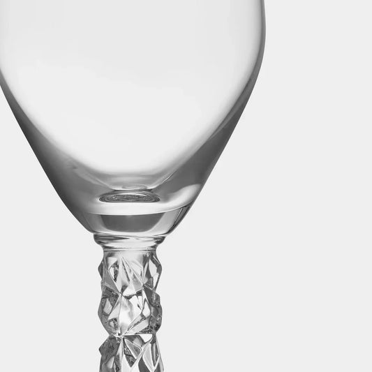 Two clear glass champagne flutes with intricate designs on a white background