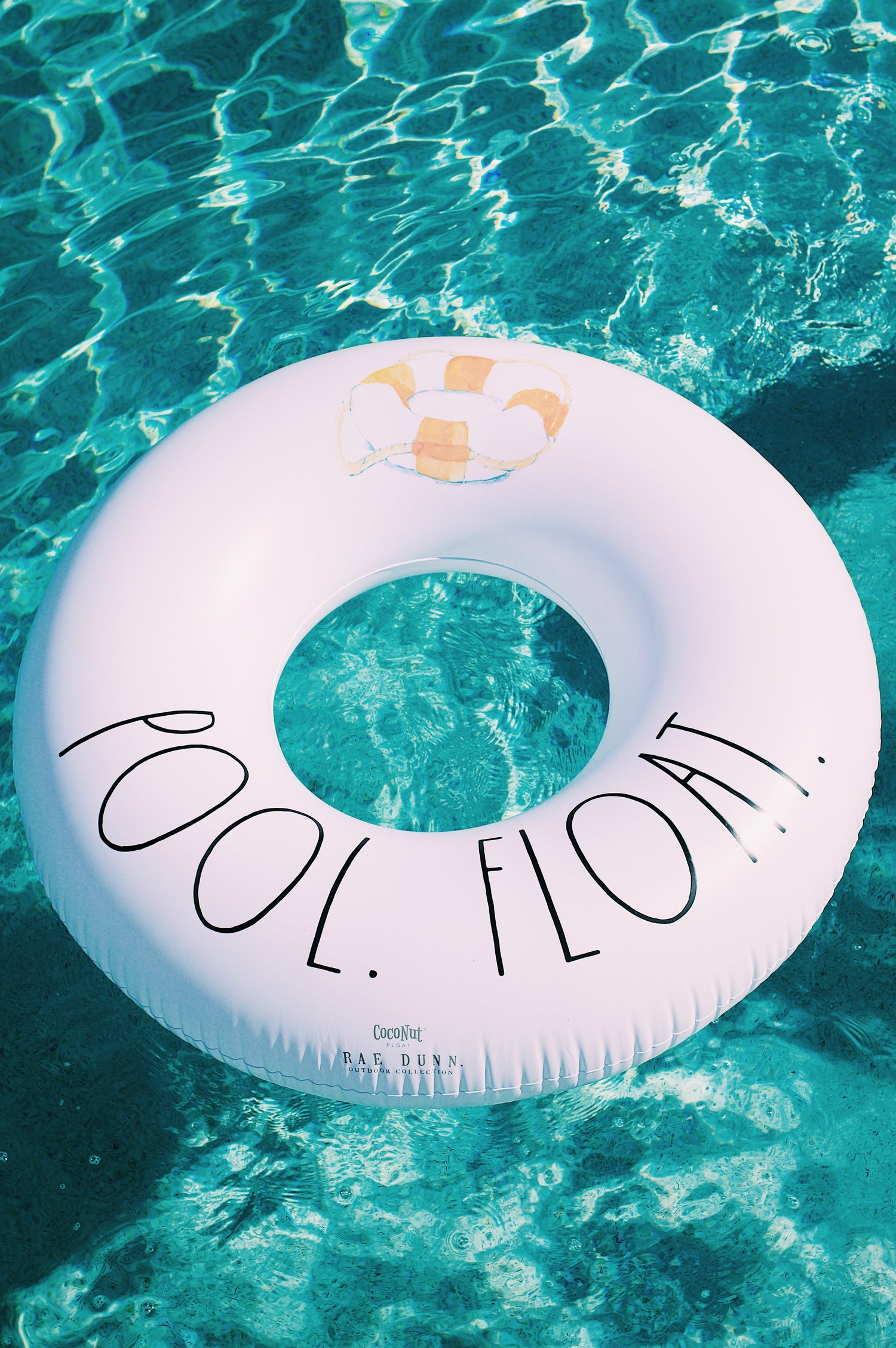 White inflatable pool float with 'Pool Float' text floating in clear blue water