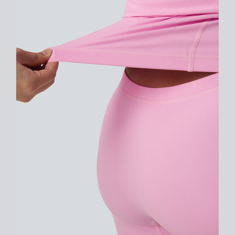 Close-up of pink leggings being stretched on a light gray background