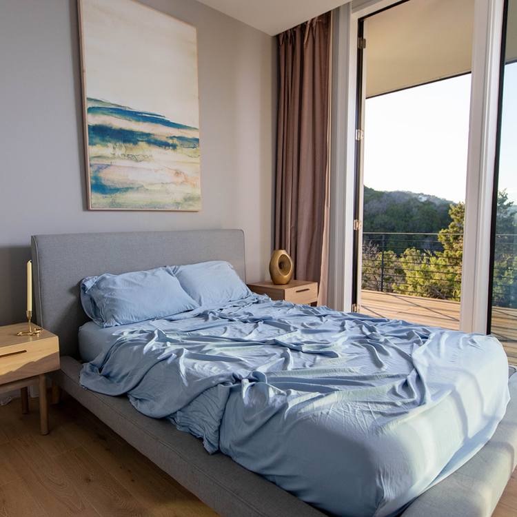 Bedroom with a bed, nightstands, and a painting on the wall.