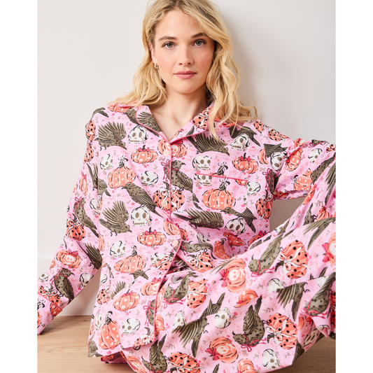 Woman wearing a pink floral onesie against a plain background