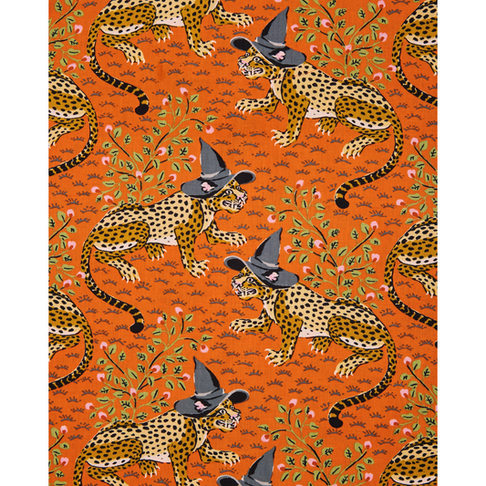 Woman wearing a patterned orange pajama set against a plain background