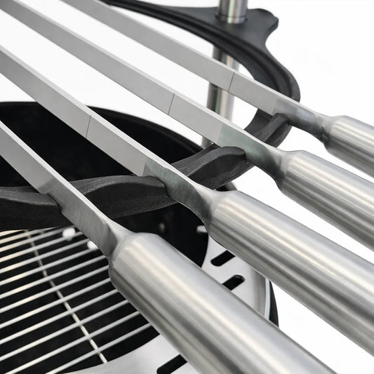Black portable grill with metal skewers on a white background