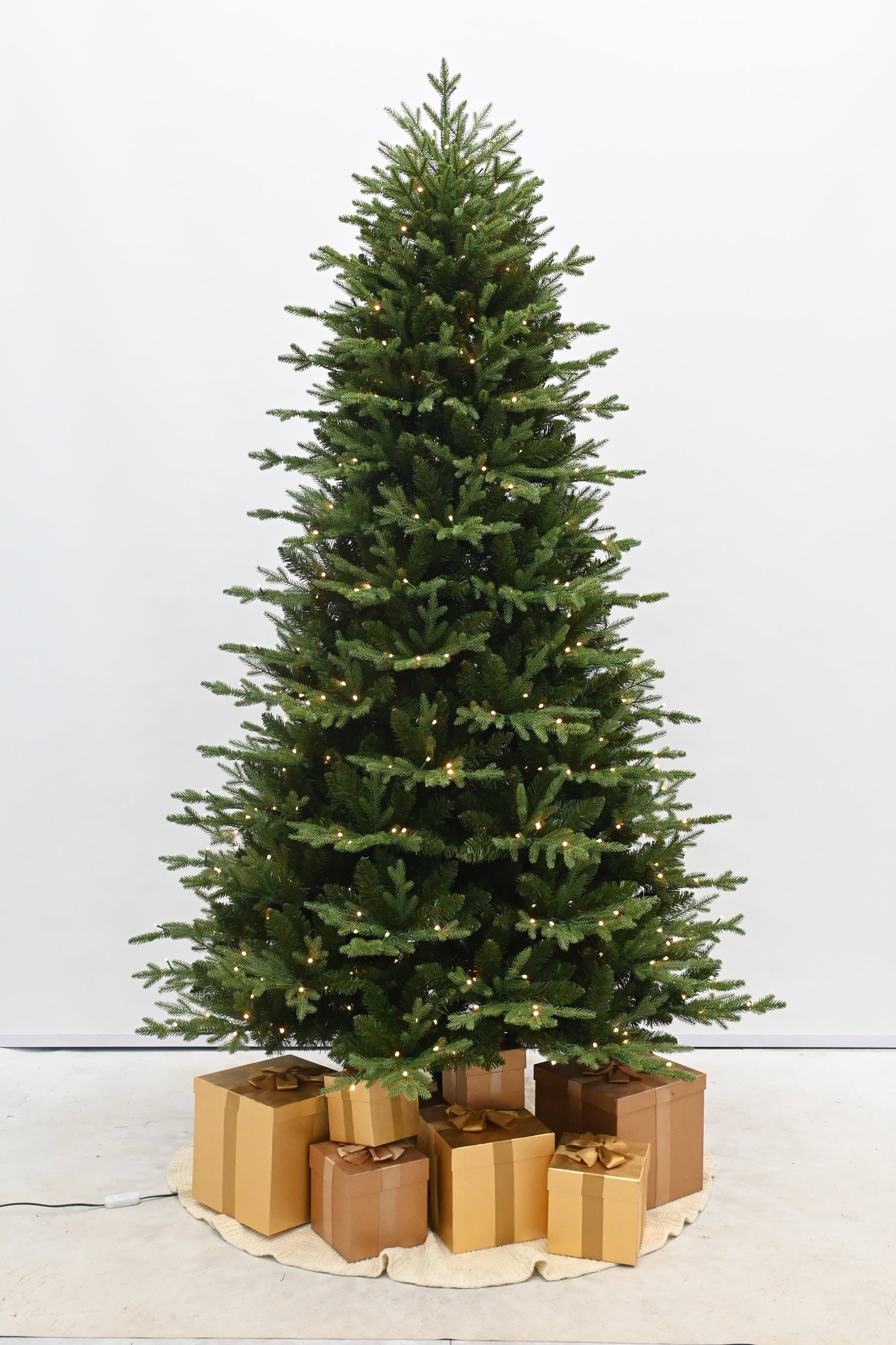 Decorative Christmas tree with gold presents on a white background