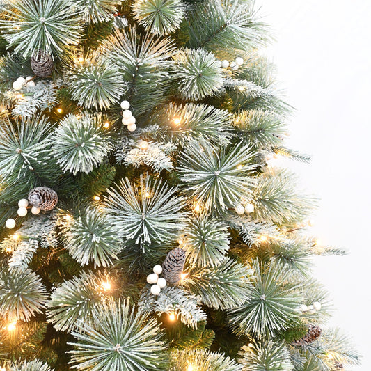 Decorated Christmas tree with lights and presents in a living room with a fireplace.