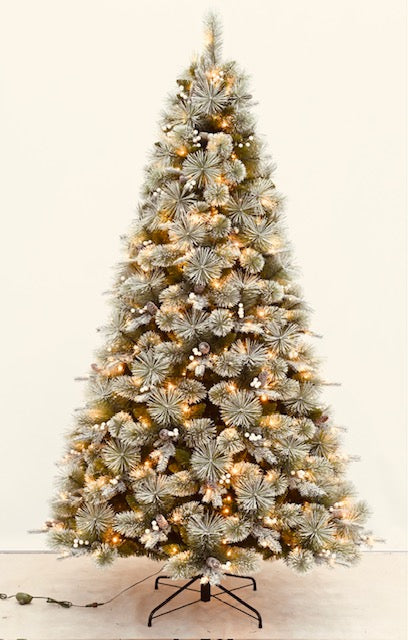 Decorated Christmas tree with lights and presents in a living room with a fireplace.