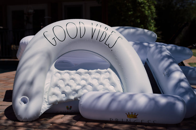 Inflatable cloud-shaped structure with 'Good Vibes' text on a blurred outdoor background