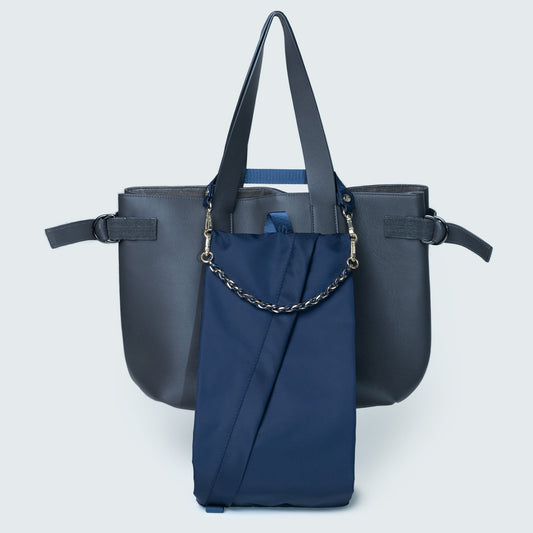 Navy blue handbag with a chain detail on a light gray background