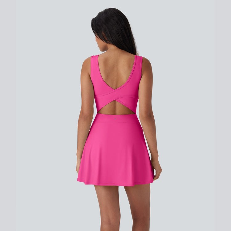 Pink dress with cut-out back on a model against a light gray background