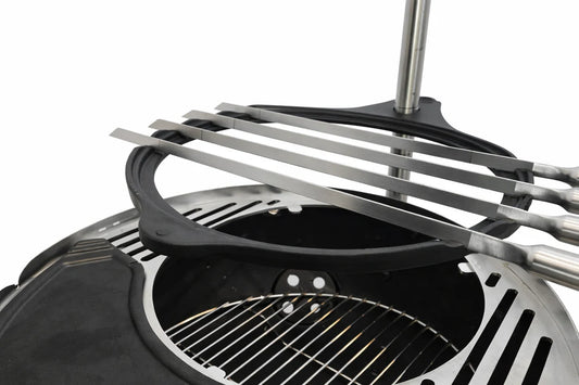Black portable grill with metal skewers on a white background