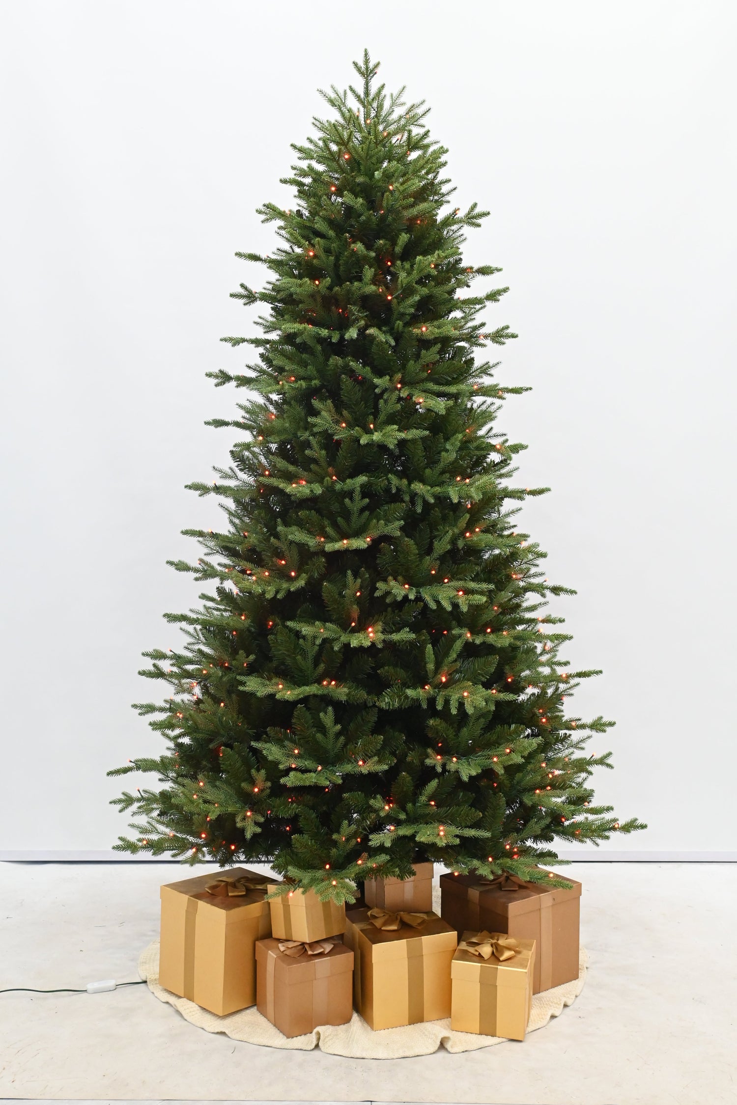 Decorated Christmas tree with lights and presents on a white background
