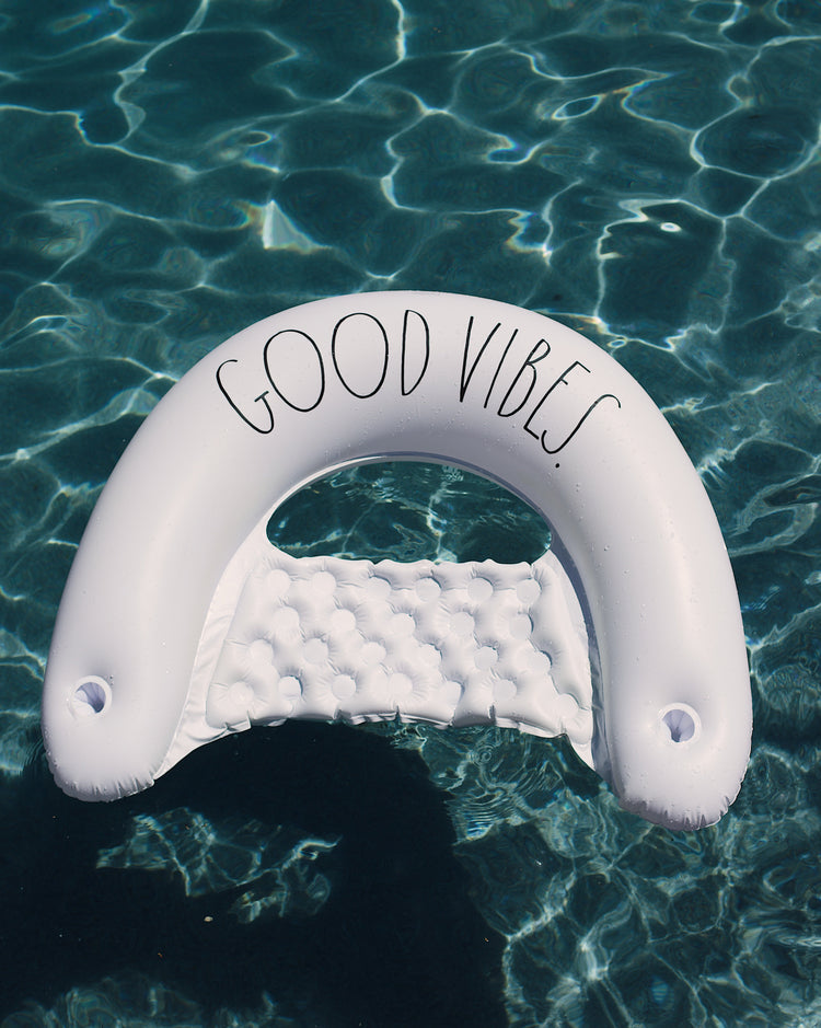 Inflatable pool toy with 'Good Vibes' text floating on water