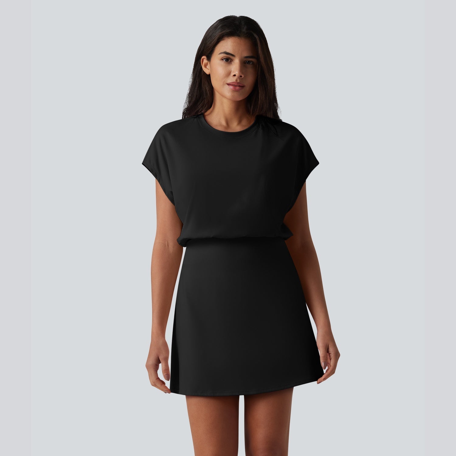 Woman wearing a black dress against a plain background