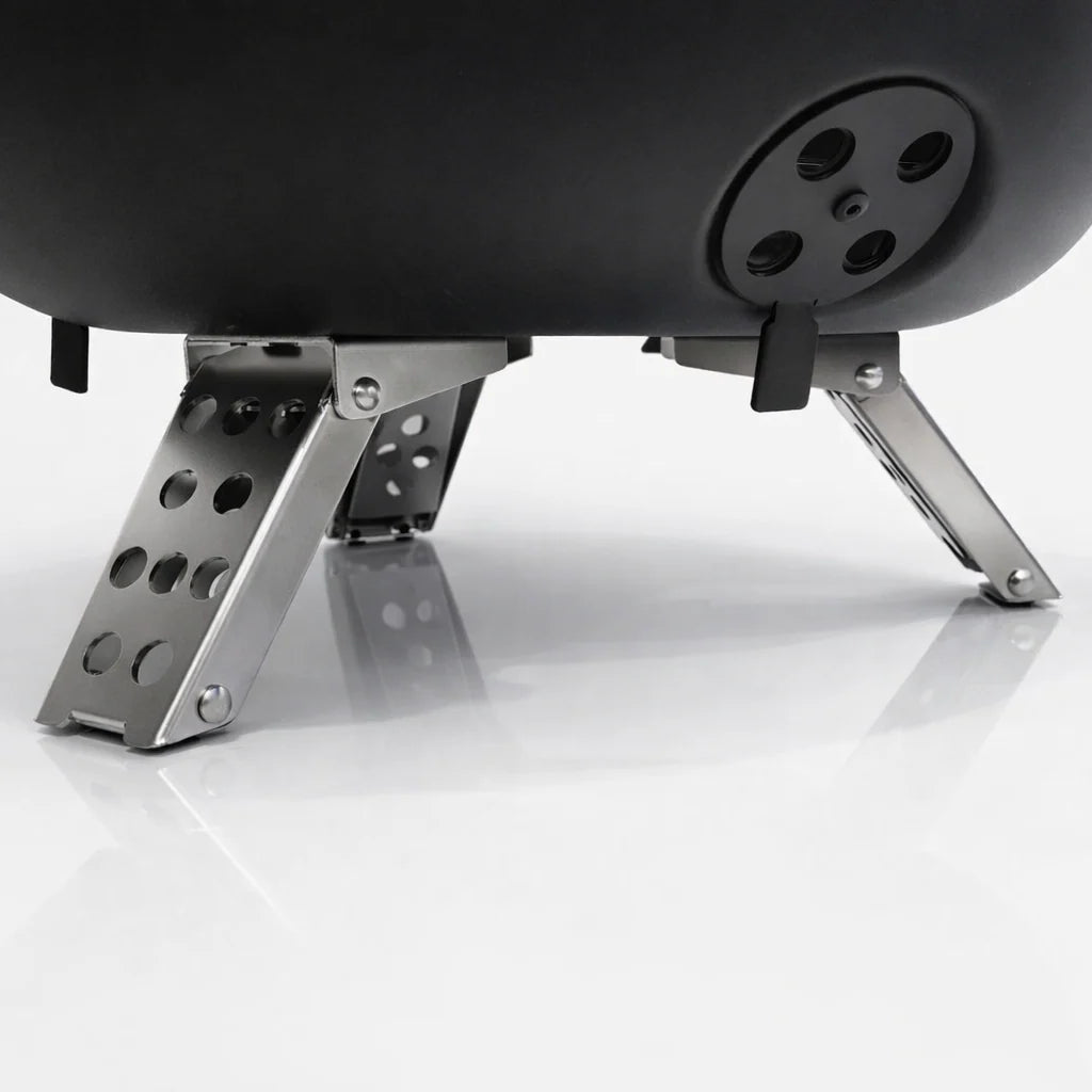 Close-up of a black spherical object with metallic legs on a white background