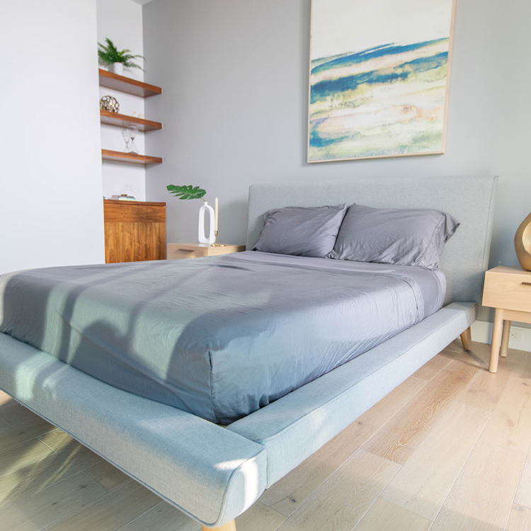 Modern bedroom with a bed, nightstands, and abstract art on the wall.