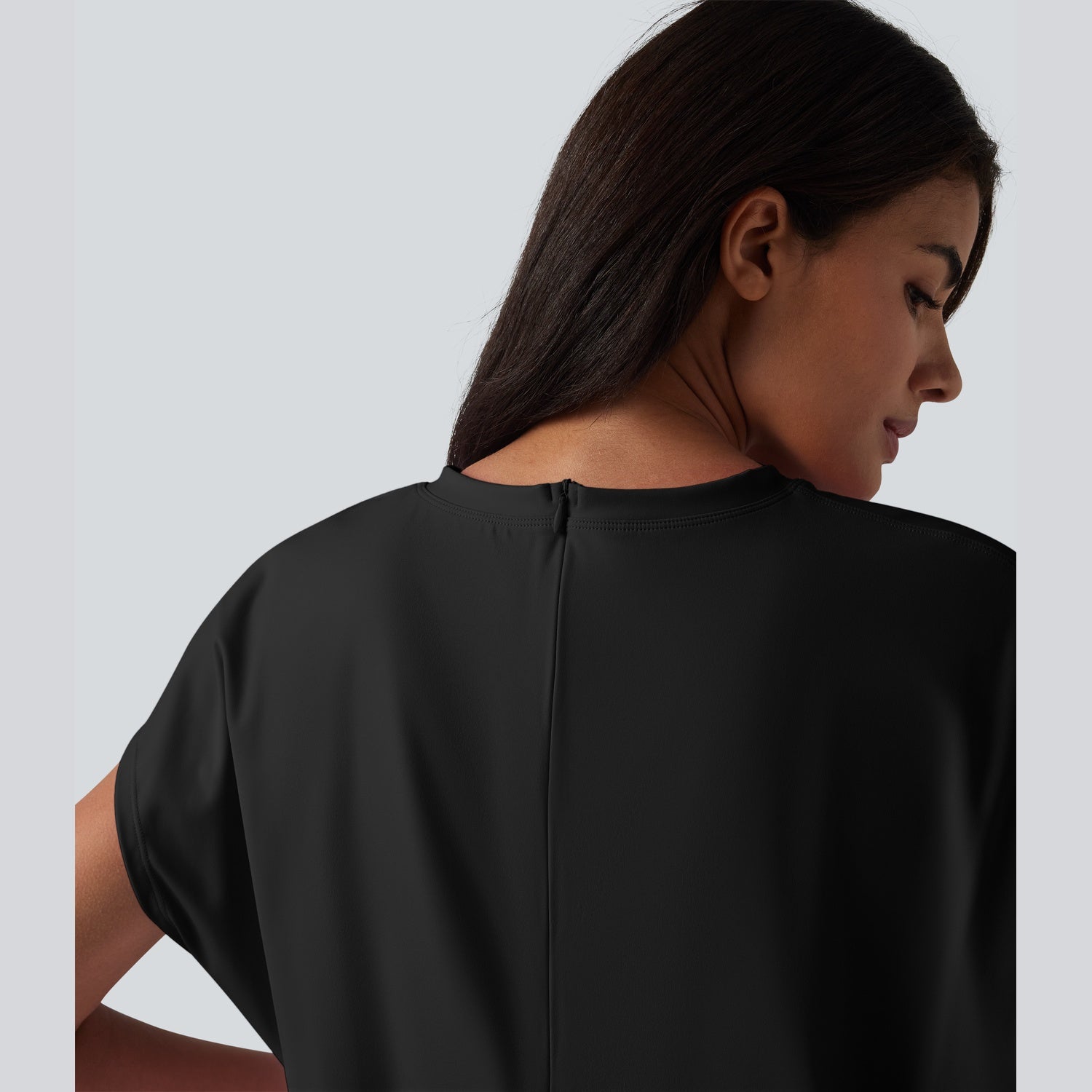 Woman wearing a black top against a light gray background