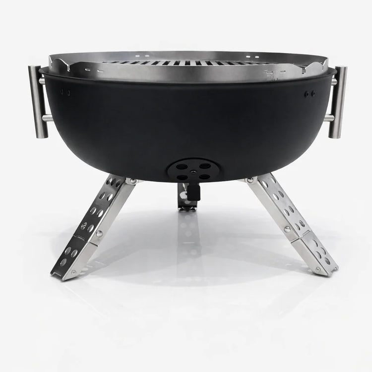 Black portable fire pit with metal legs on a white background