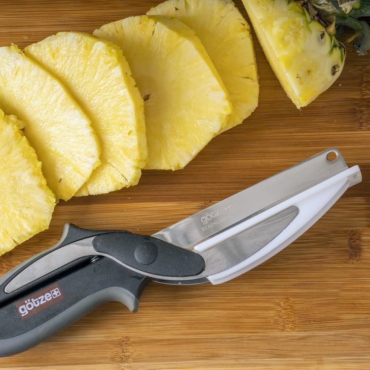 Sliced pineapple on a wooden cutting board with a knife