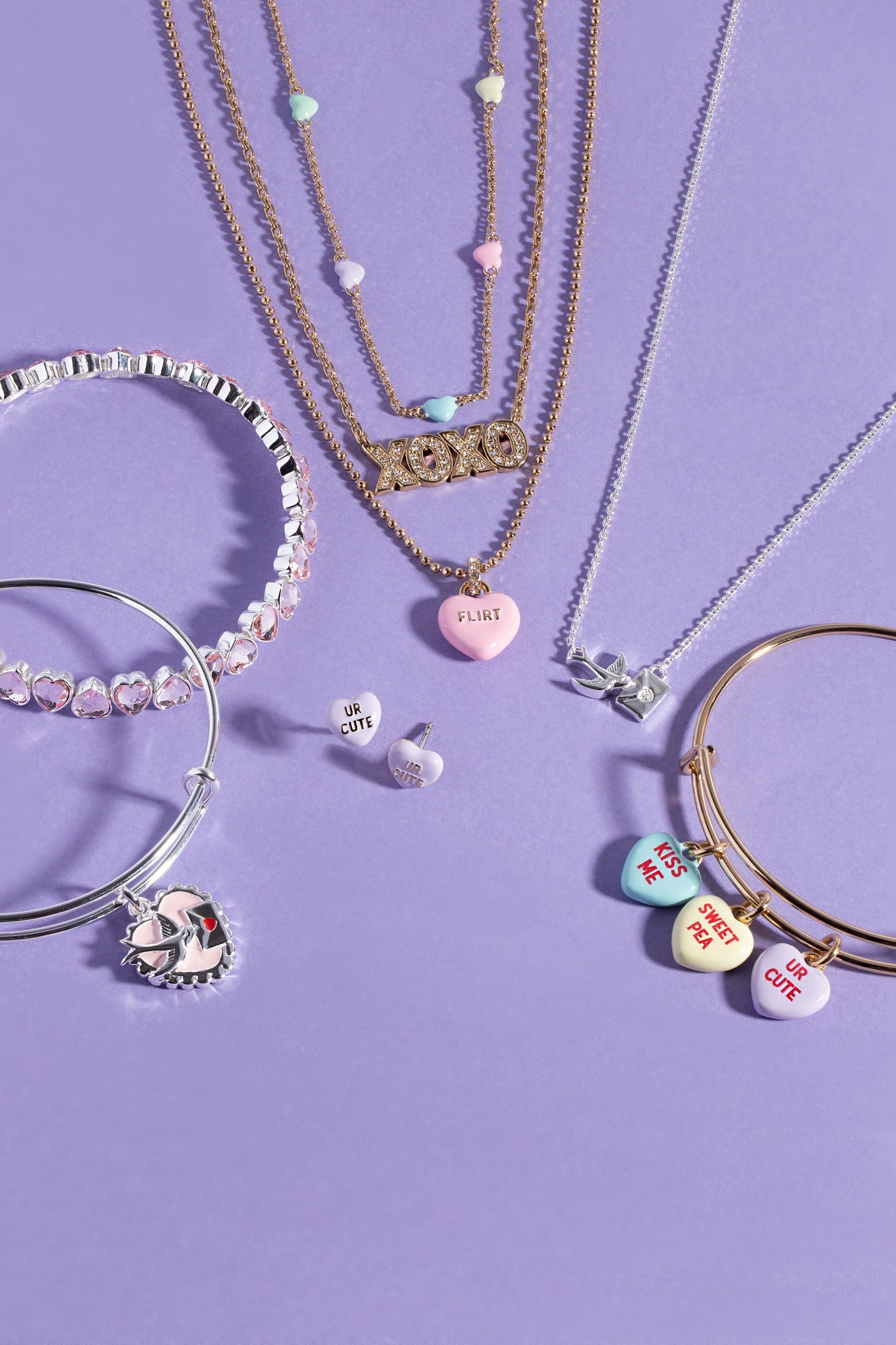 Jewelry set including necklaces, bracelets, and earrings on a purple background