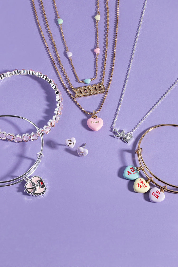 Jewelry set including necklaces, bracelets, and earrings on a purple background