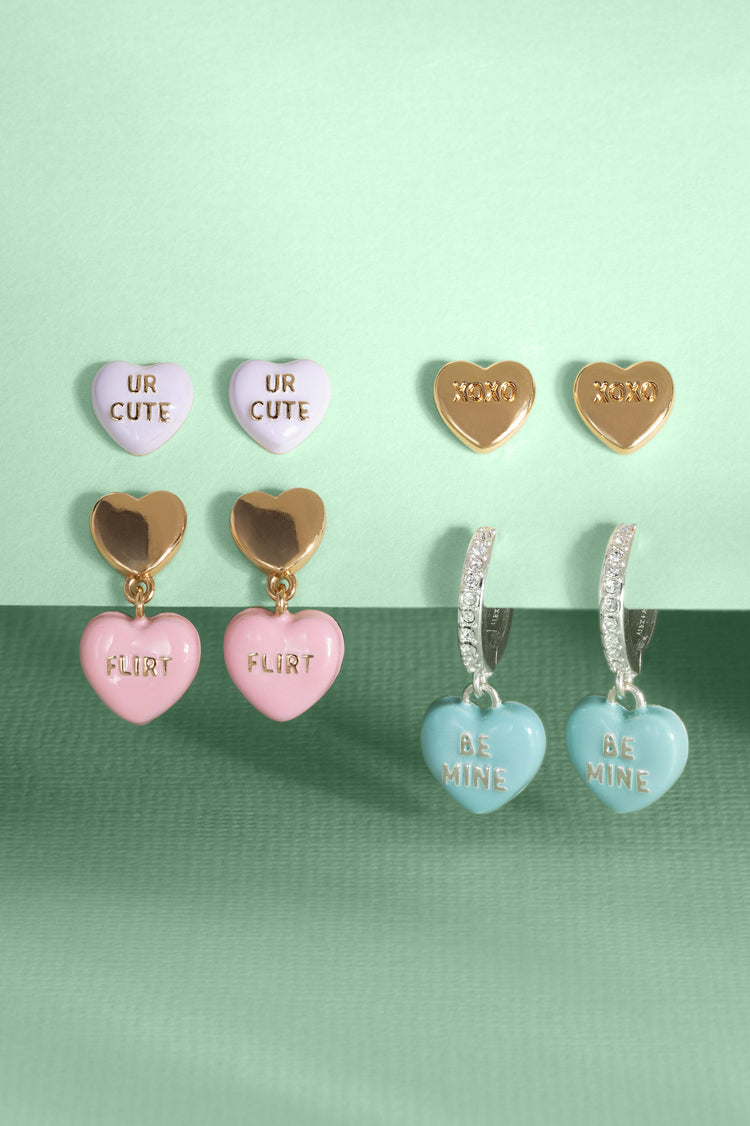 Heart-shaped earrings with various inscriptions on a green background