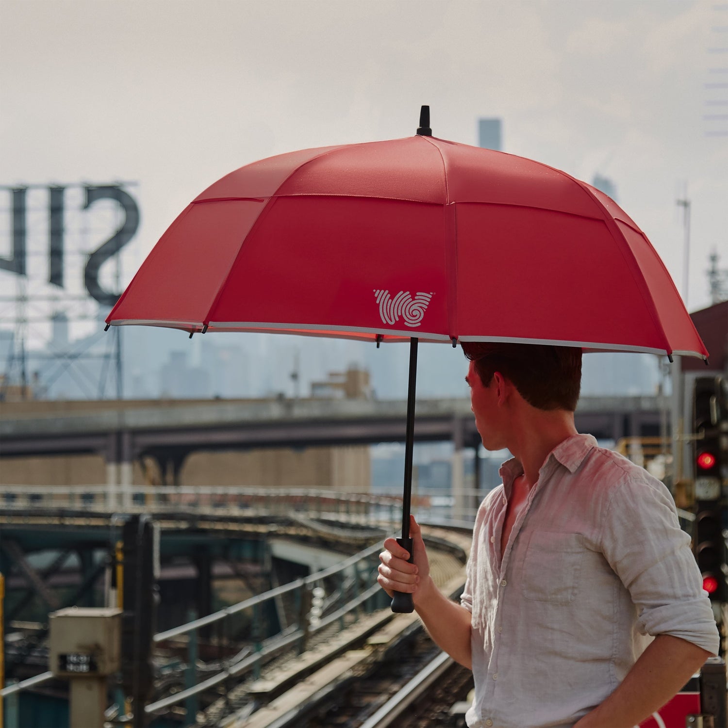 Man walking with Weatherman Stick Umbrella in red.