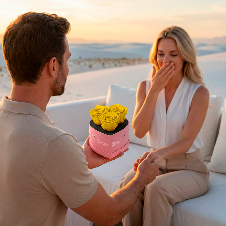 Man presenting a pink box with yellow roses to a woman on a romantic setting.