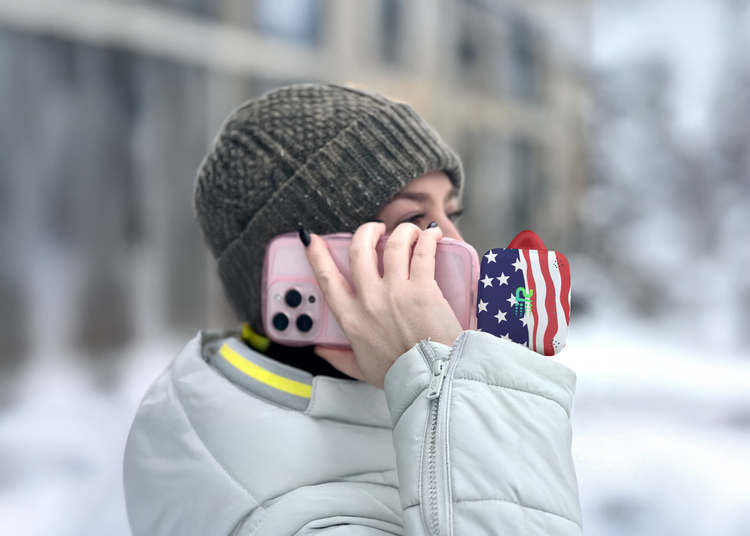 Person holding a phone with a colorful case in a snowy outdoor setting