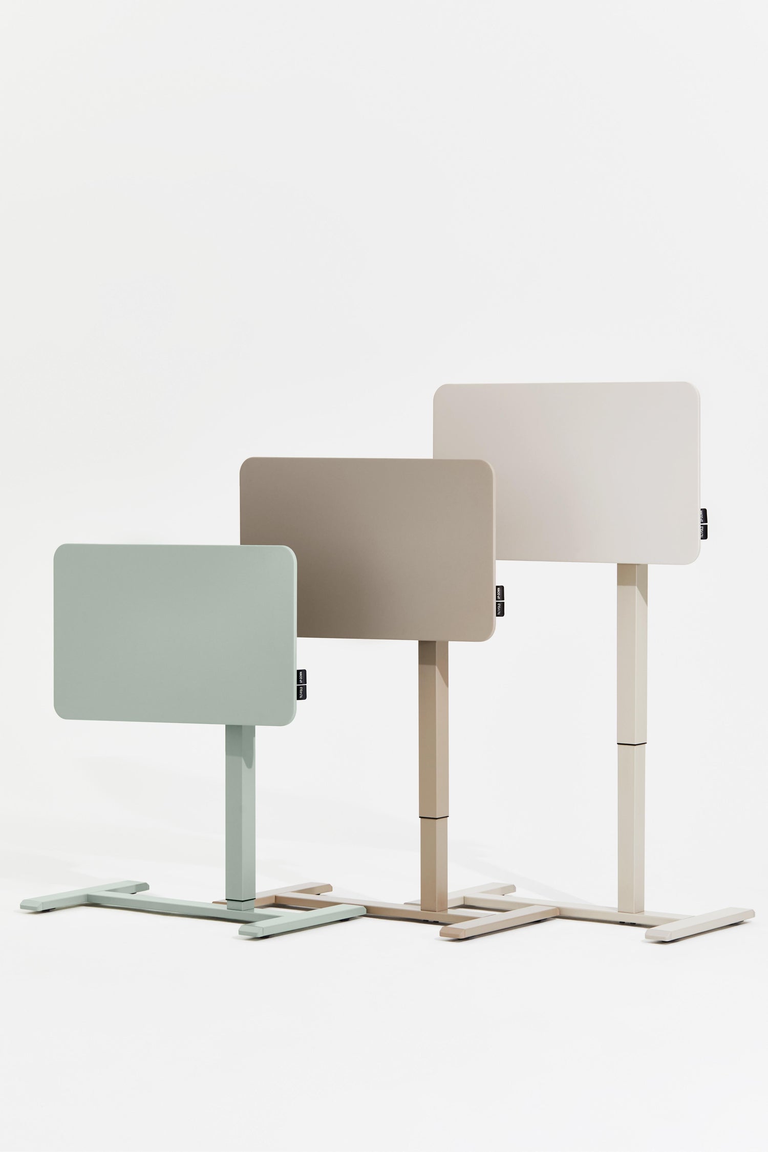 Three adjustable standing desks in different colors on a white background