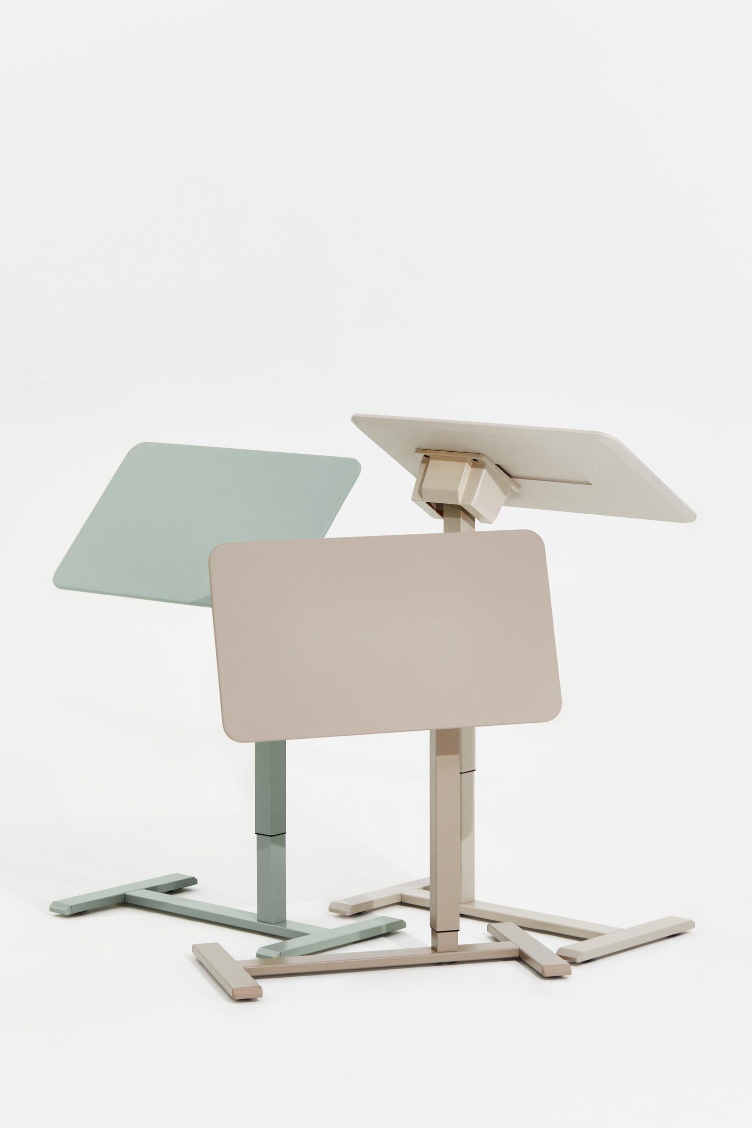 Two adjustable standing desks in pastel colors on a white background