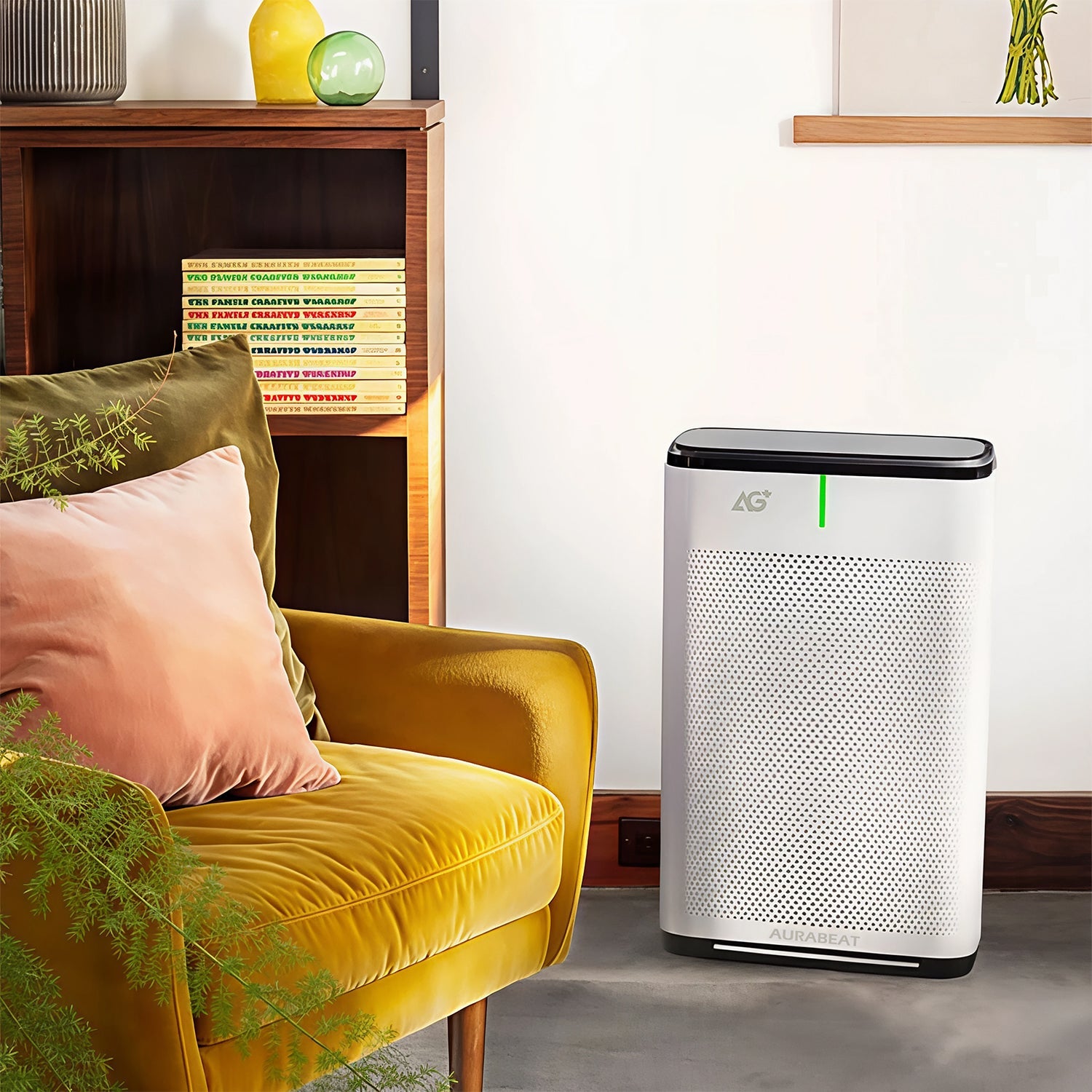 Air purifier on a gray floor with a yellow chair and wooden shelf in the background