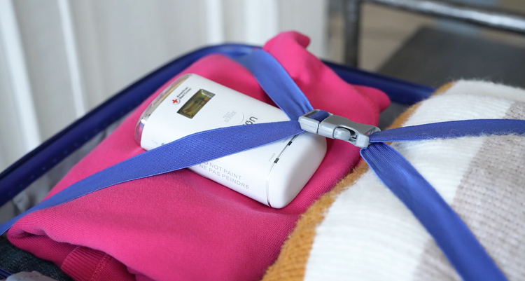 Luggage with clothes and a digital device on a trolley