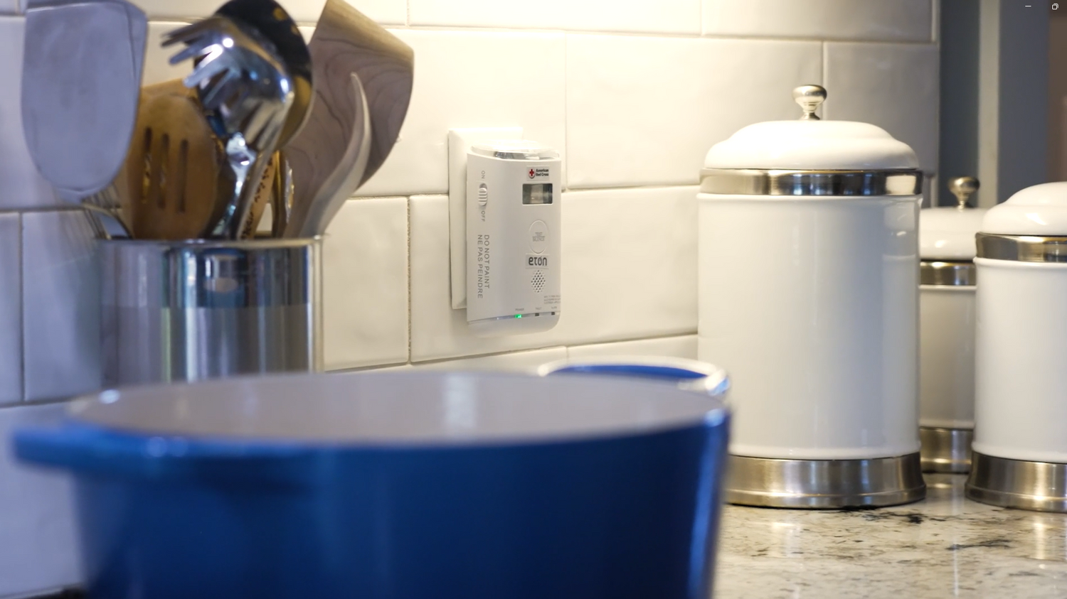 Kitchen counter with a blue pot, white trash can, and tiled wall.