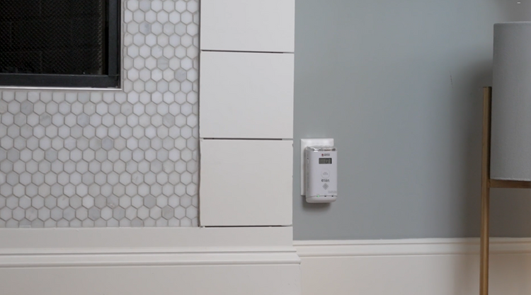 Control panel on a wall with hexagonal tile pattern and lamp in the background