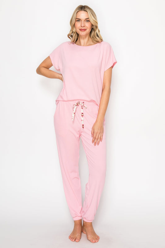 Woman wearing a pink pajama set on a white background
