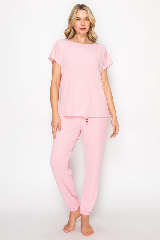 Woman wearing a pink pajama set on a white background