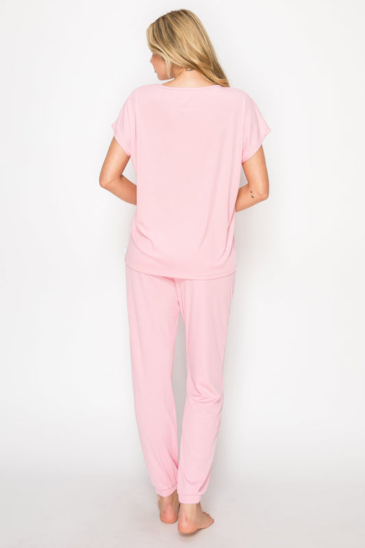 Woman wearing a pink pajama set on a white background