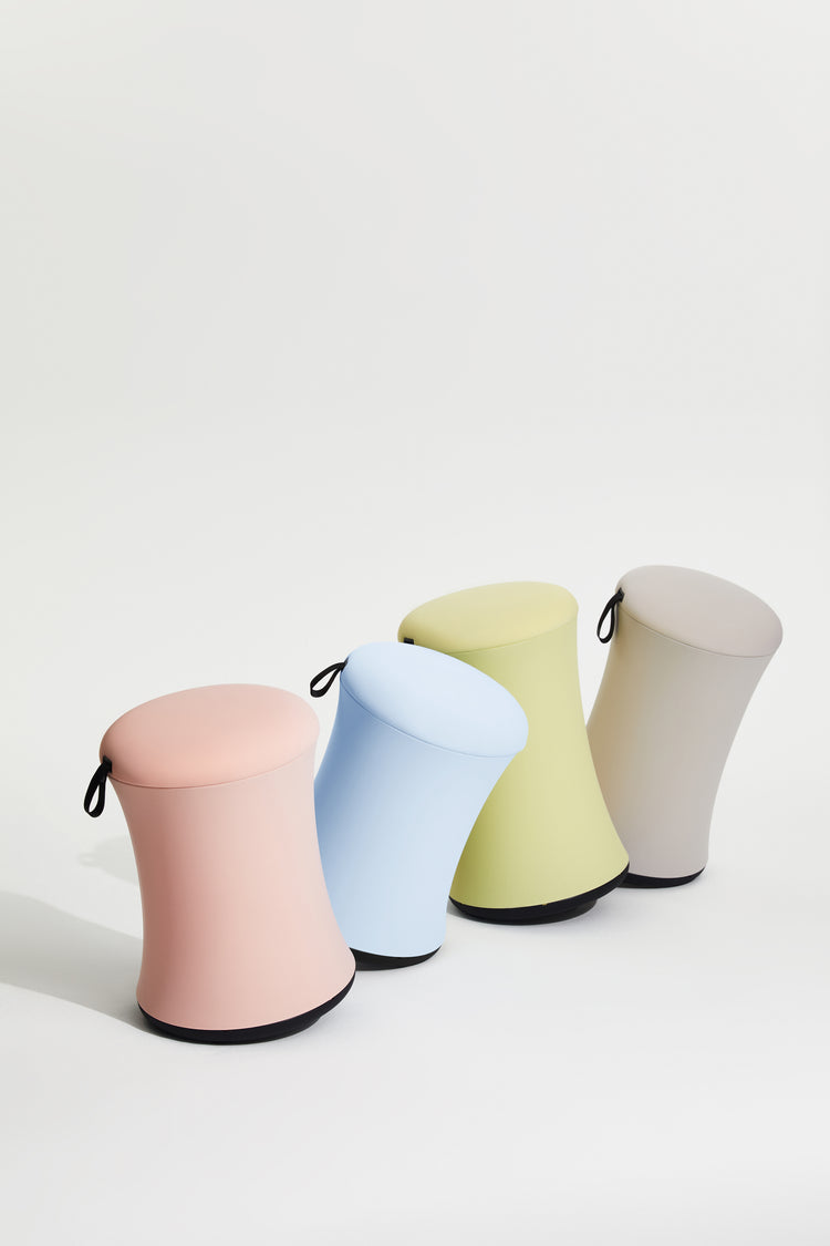 Four colorful stools in pink, blue, green, and gray on a white background