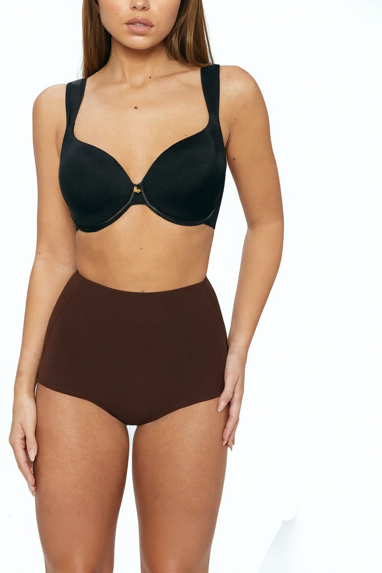 Woman wearing a black bra and brown high-waisted bikini bottom on a white background