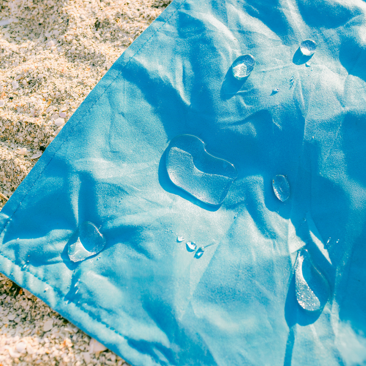 Blue plastic sheet on sandy ground