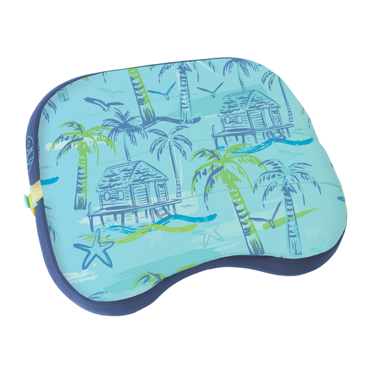 Blue pillow with tropical design featuring palm trees and huts on a white background