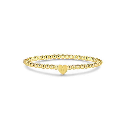 Gold beaded bracelet with a heart-shaped clasp on a white background