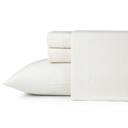 Neatly made bed with white bedding and wooden headboard in a bedroom setting.
