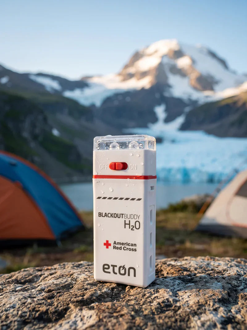 BlackoutBuddy H2O device by Eton on a rock with a scenic mountain and lake background