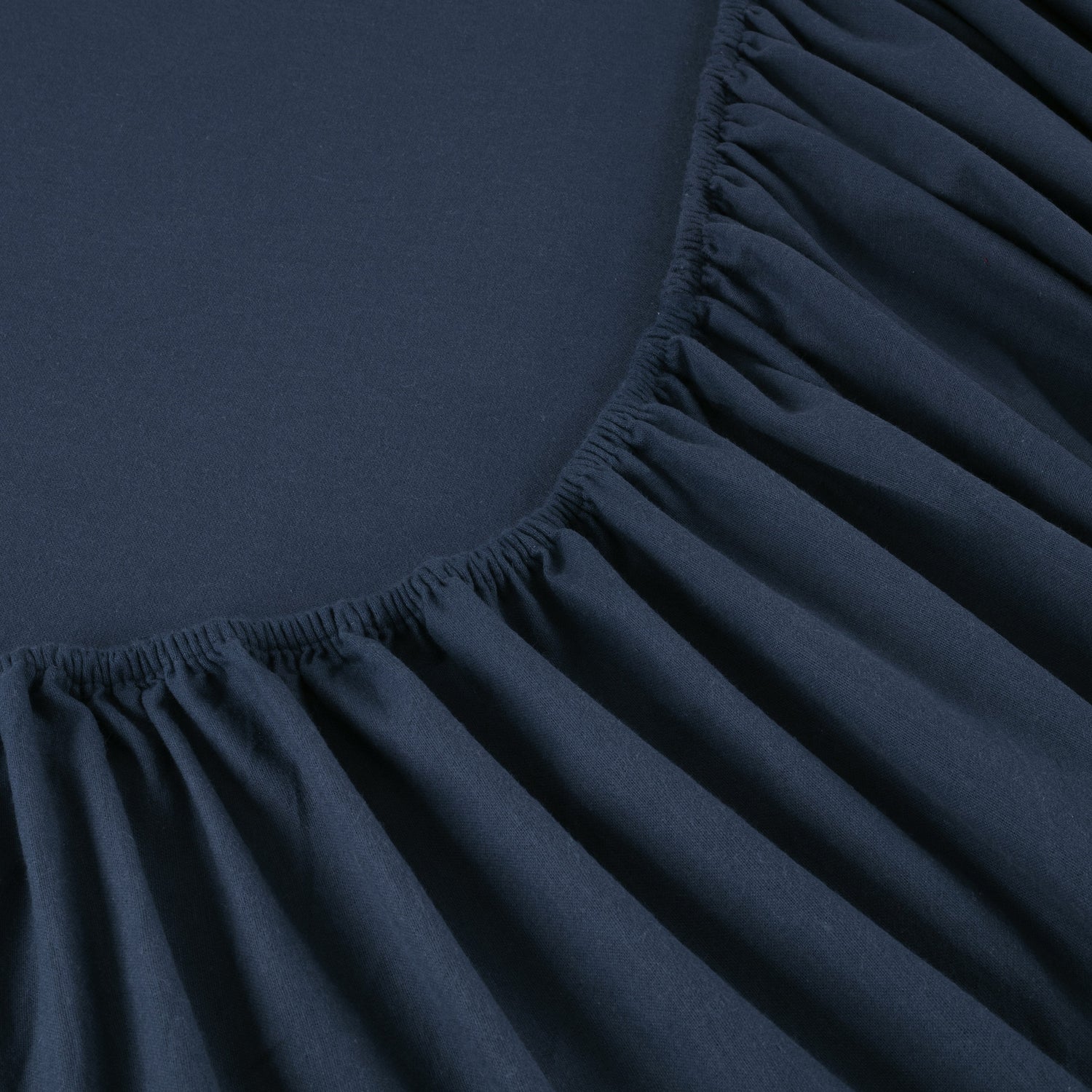 Dark blue fitted sheet corner with pleated texture