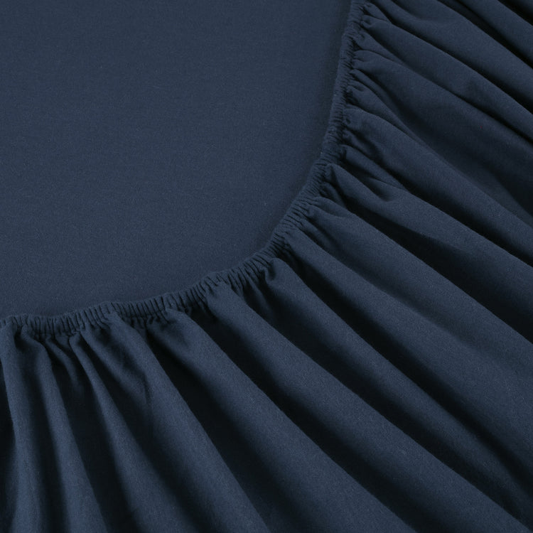 Dark blue fitted sheet corner with pleated texture