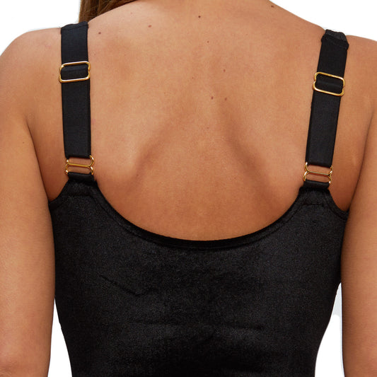 A model wears a black velvet bodysuit on a white background
