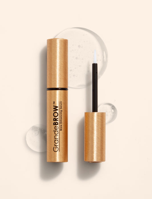 GrandeBrow brow enhancing serum with gold packaging and black applicator on a white background