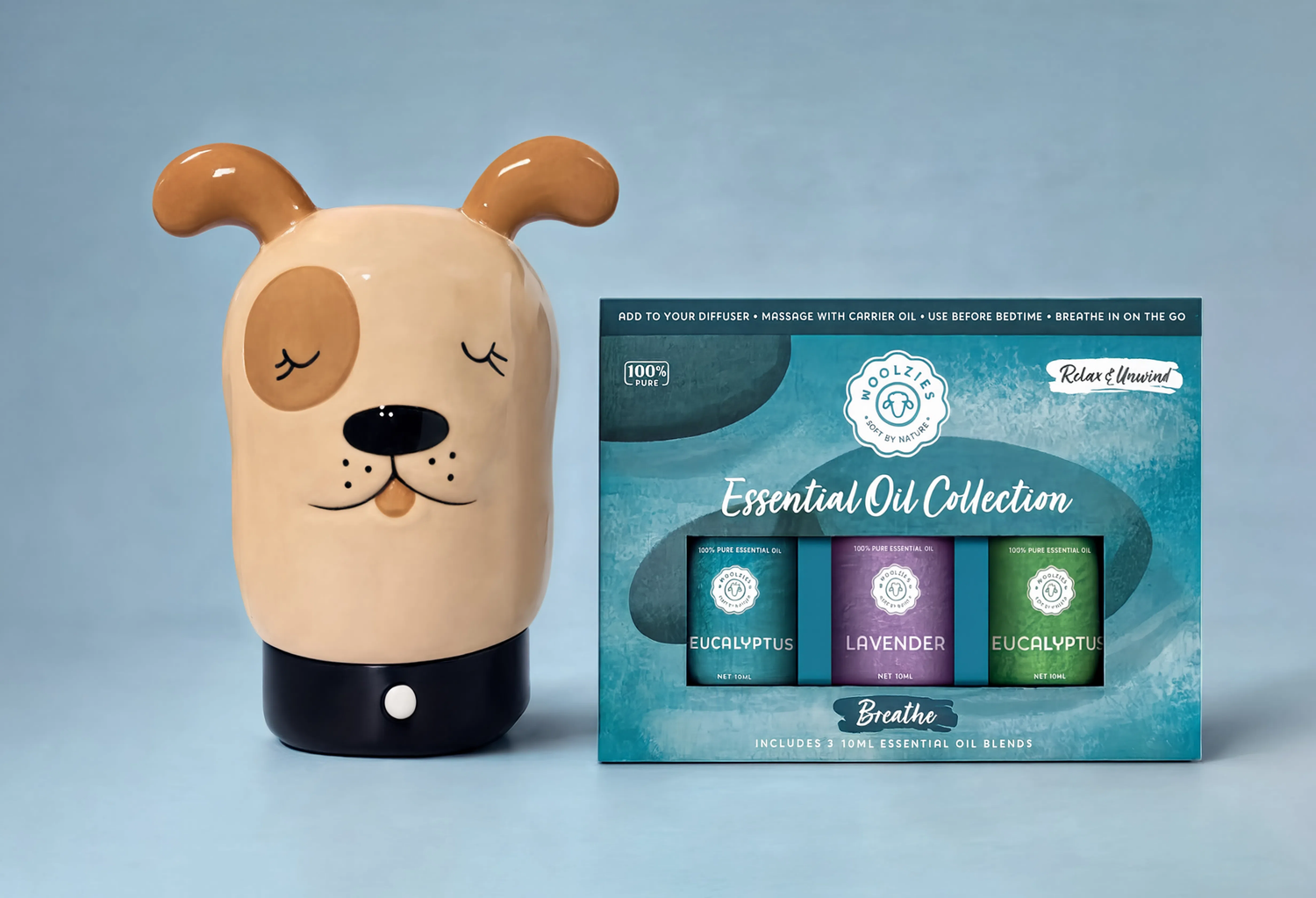 Dog-shaped diffuser with a box of essential oil collection on a light blue background