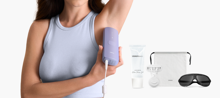 Woman using a purple electronic device on her arm with a bottle, pouch, and sunglasses in the foreground.